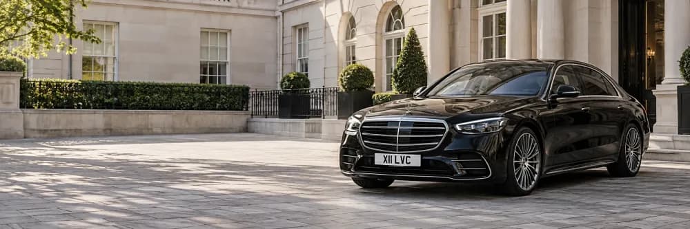 Black Mercedes-Benz S-Class parked outside an elegant Mayfair hotel in London.